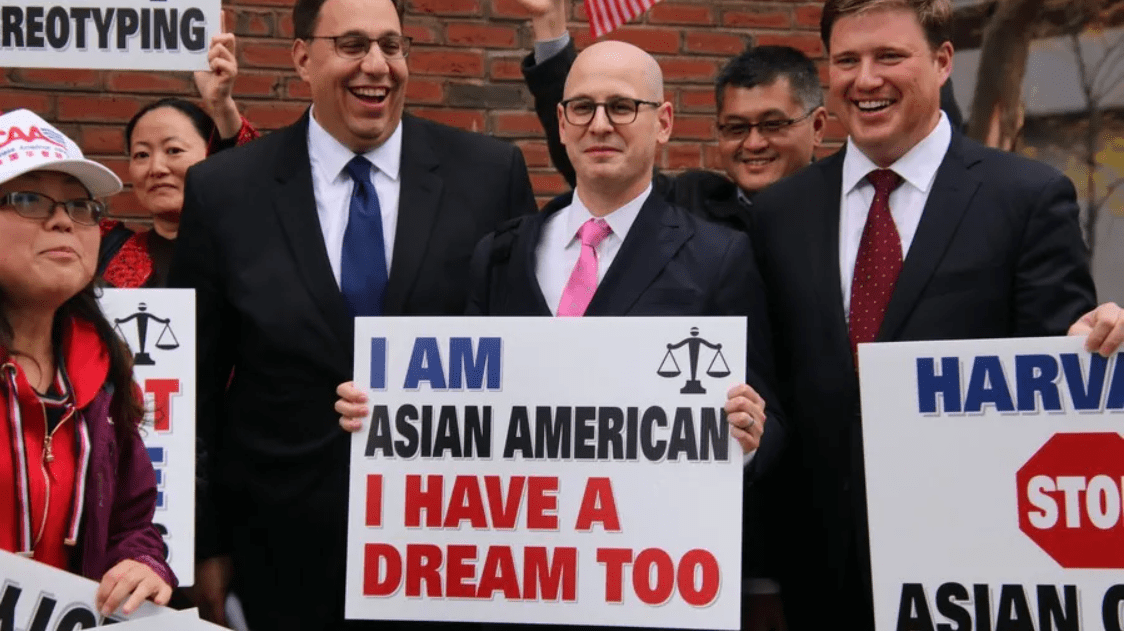 律师手举标语牌合影，标语上写道“我是亚裔，我也有梦想”，图源：Harvard Crimson, Amy Y. Li